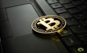 Illustration of a beginner learning how to start investing in crypto in 2025 with a laptop, charts, and cryptocurrencies.