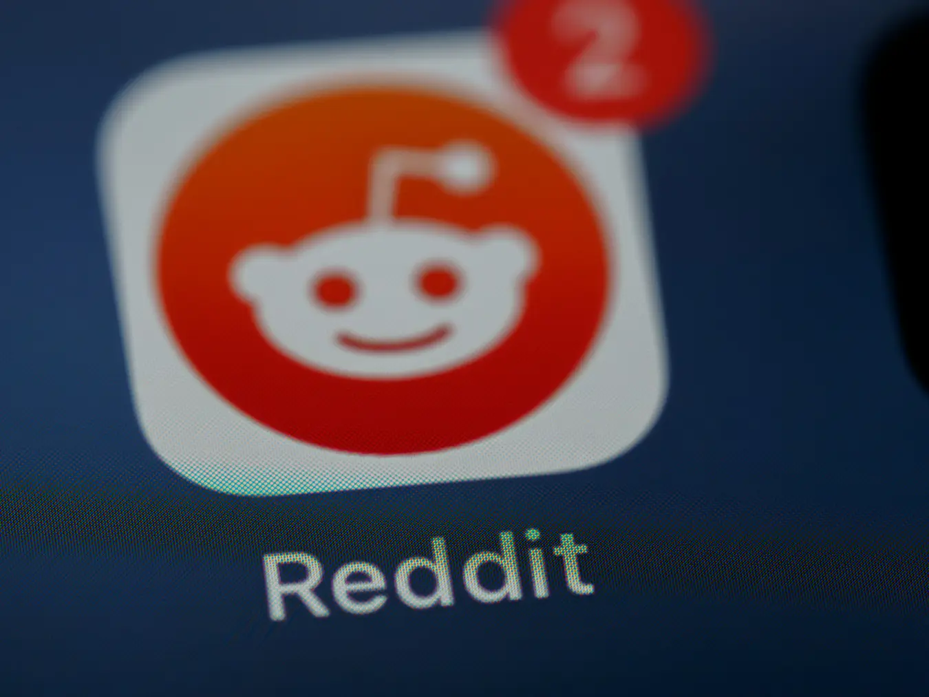 Reddit Stock Price Prediction 2025. Close-up of the Reddit app icon on a smartphone screen, featuring the signature Snoo logo with notification alerts.