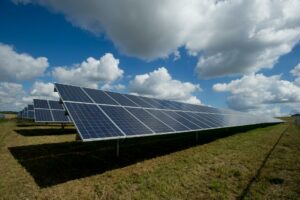 Solarmodule von Meyer Burger auf einem Feld unter blauem Himmel mit Wolken.